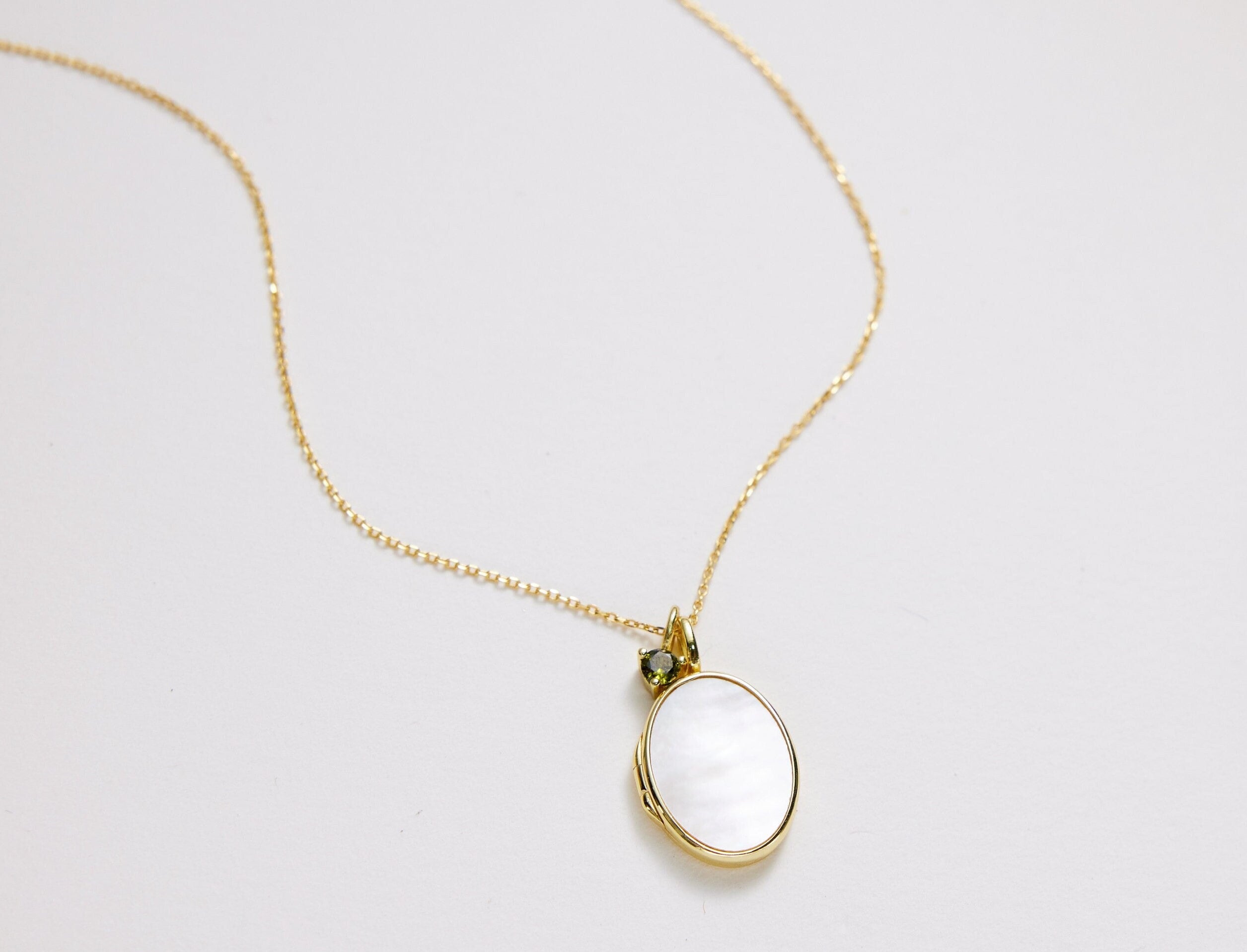 Open mother-of-pearl oval locket necklace ready for a small photograph