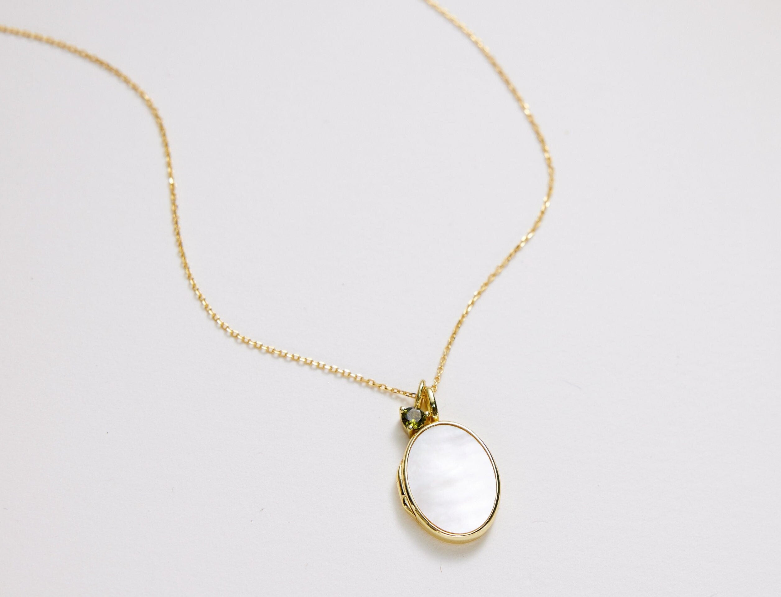 Open mother-of-pearl oval locket necklace ready for a small photograph