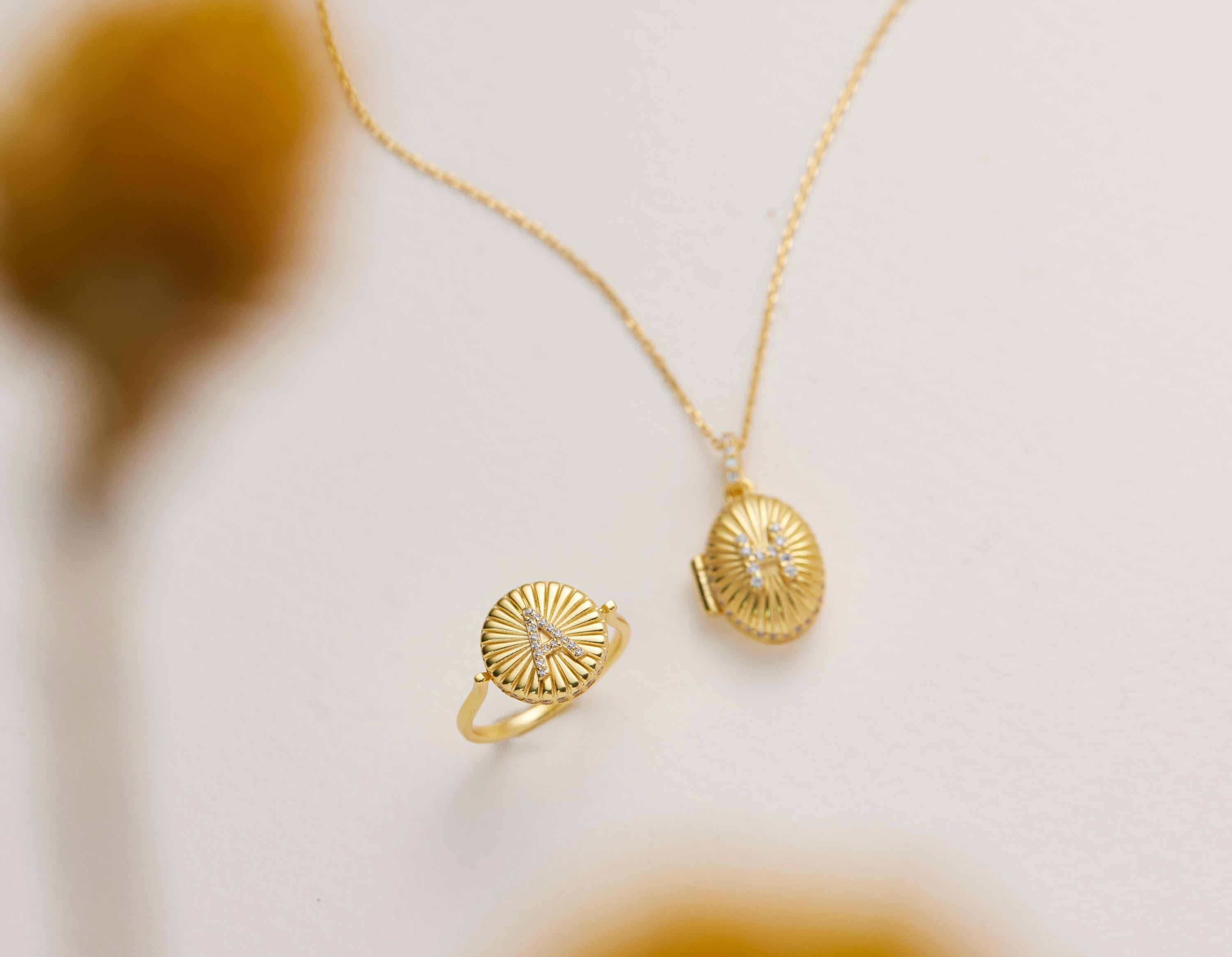 two pieces of gold jewelry: a ring and a necklace.