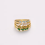 Gold ring with gemstones on a light gray background