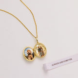 Gold necklace with a locket featuring two photos and a 'Always and Forever' card on a light background