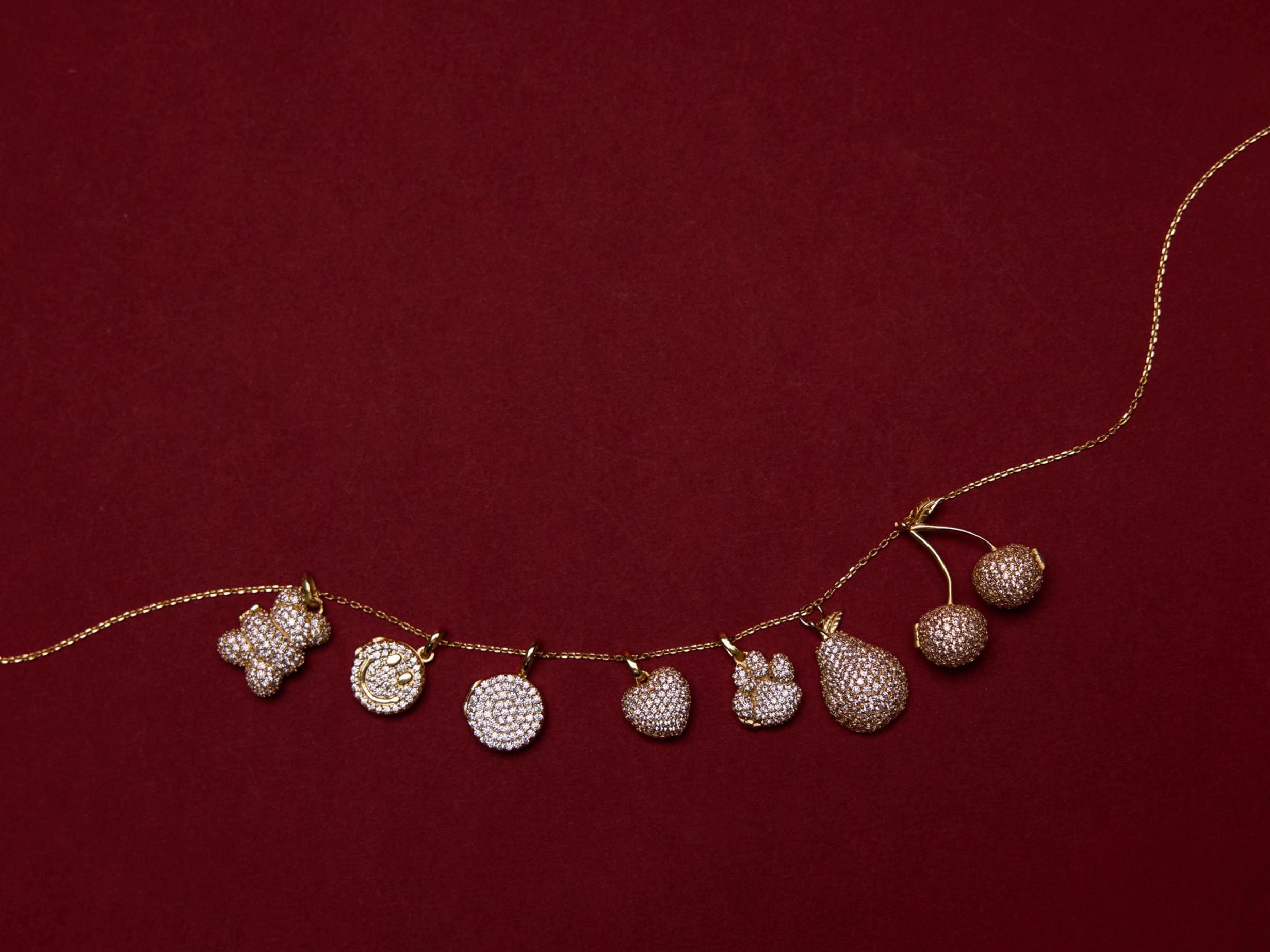 Necklace with paw print and heart pendants on a red background