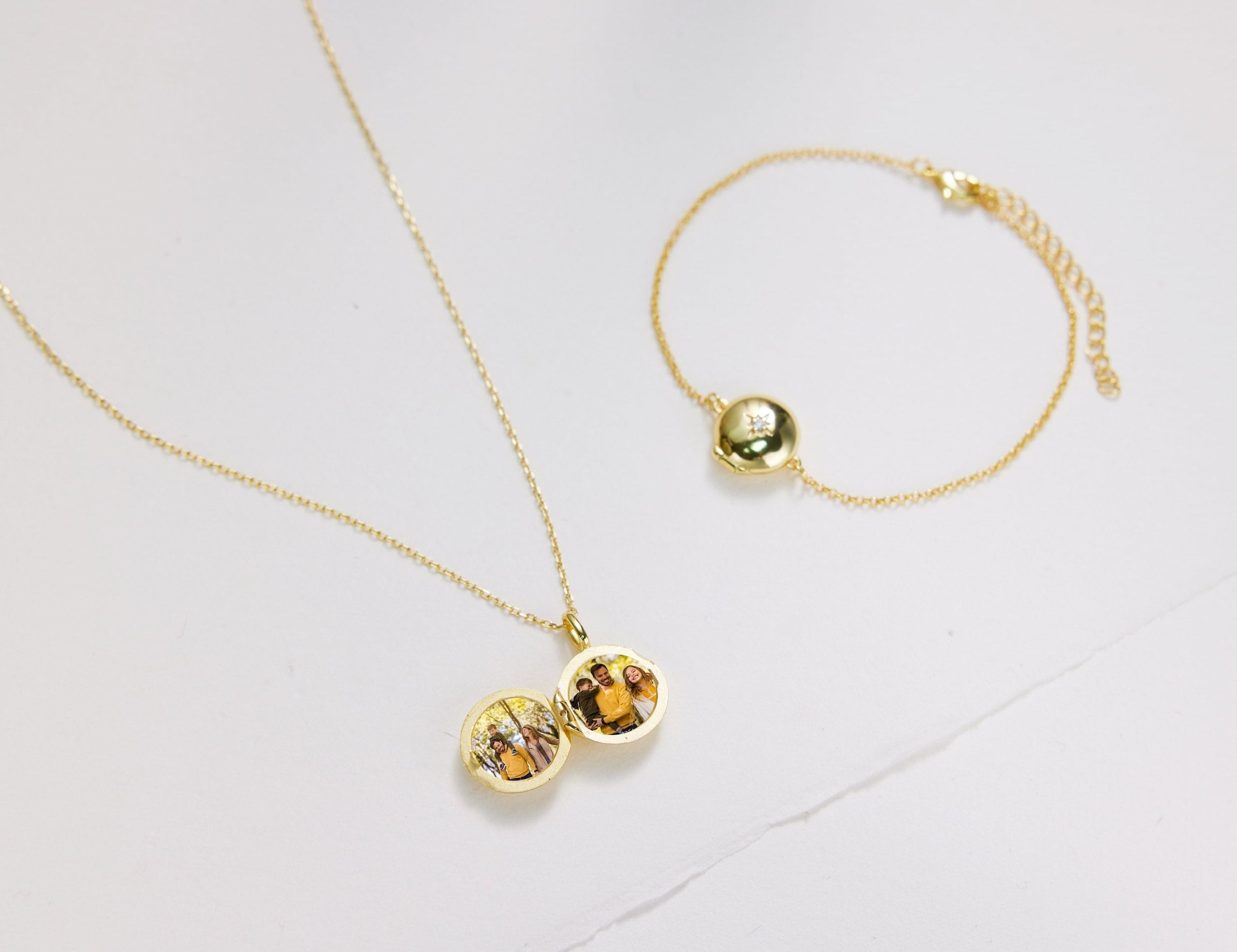 Gold necklace and bracelet with embedded stones on a light gray background