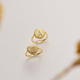 Two gold rings with unique designs are displayed against a white background.