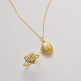 a gold necklace and a gold ring with a heart-shaped design, both adorned with small diamonds.