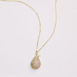 Gold necklace with a teardrop-shaped pendant on a light gray background