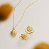 a necklace, two rings, and a locket, all made of gold and adorned with intricate designs.