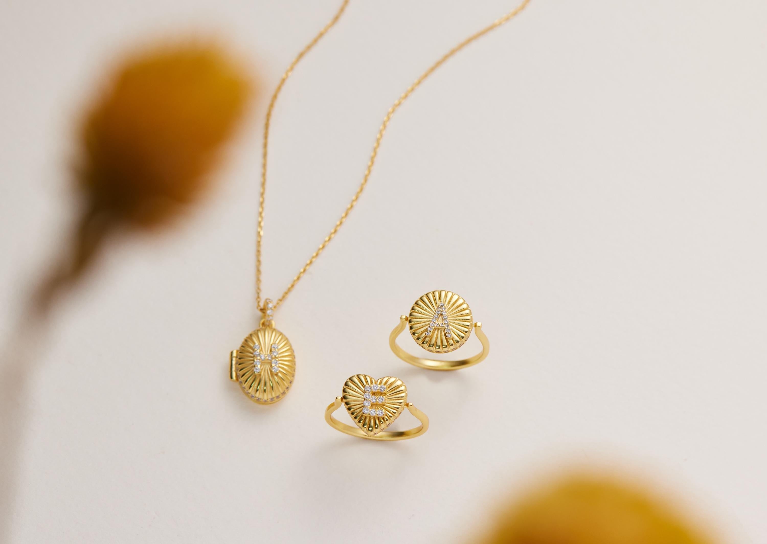 a necklace, two rings, and a locket, all made of gold and adorned with intricate designs.