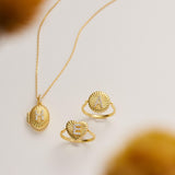 a necklace, two rings, and a locket with a pendant, all made of gold and adorned with intricate designs.