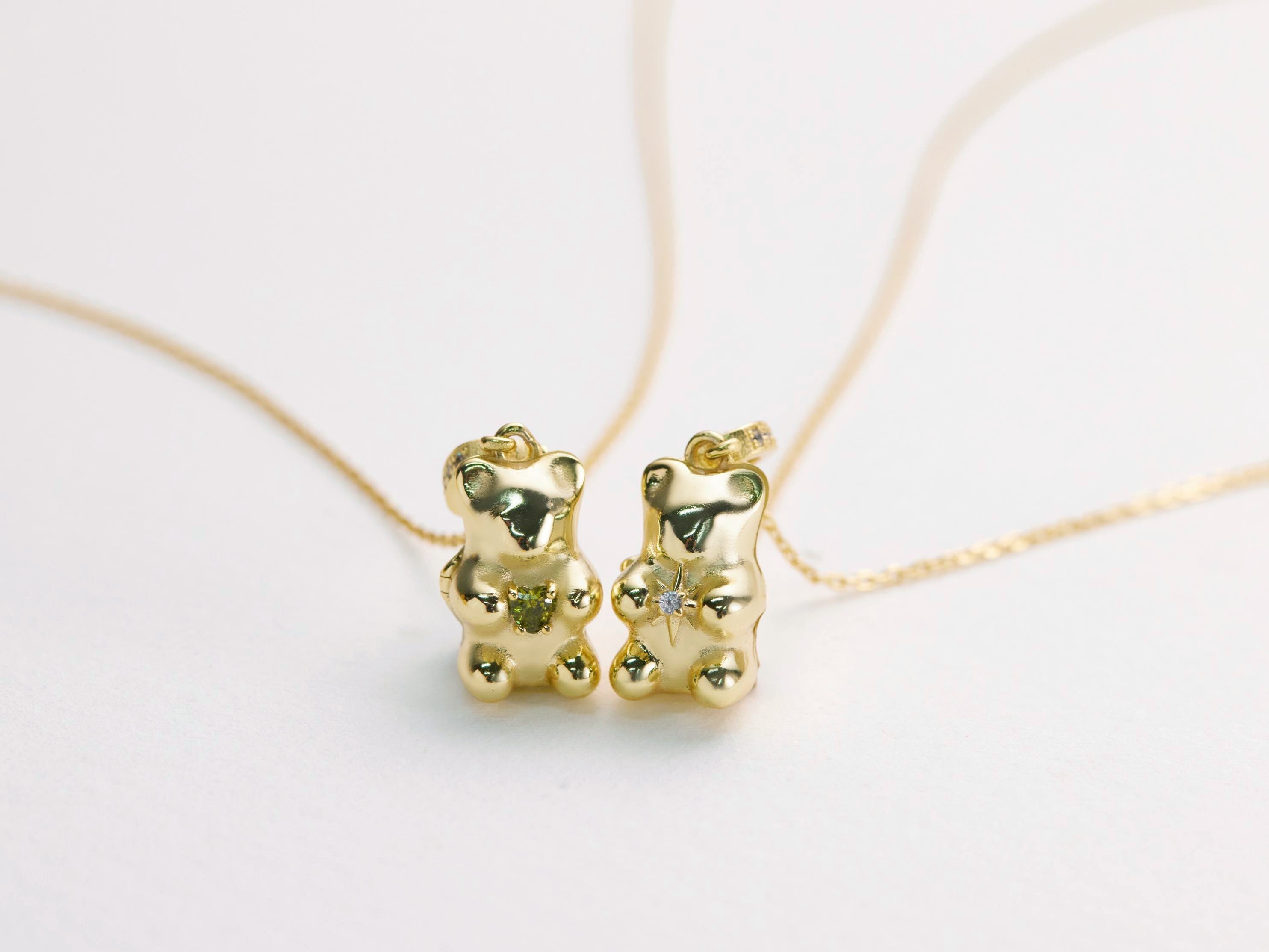 Gold bear-shaped pendant on a thin chain against a light background