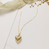 Gold heart-shaped necklace on a light background
