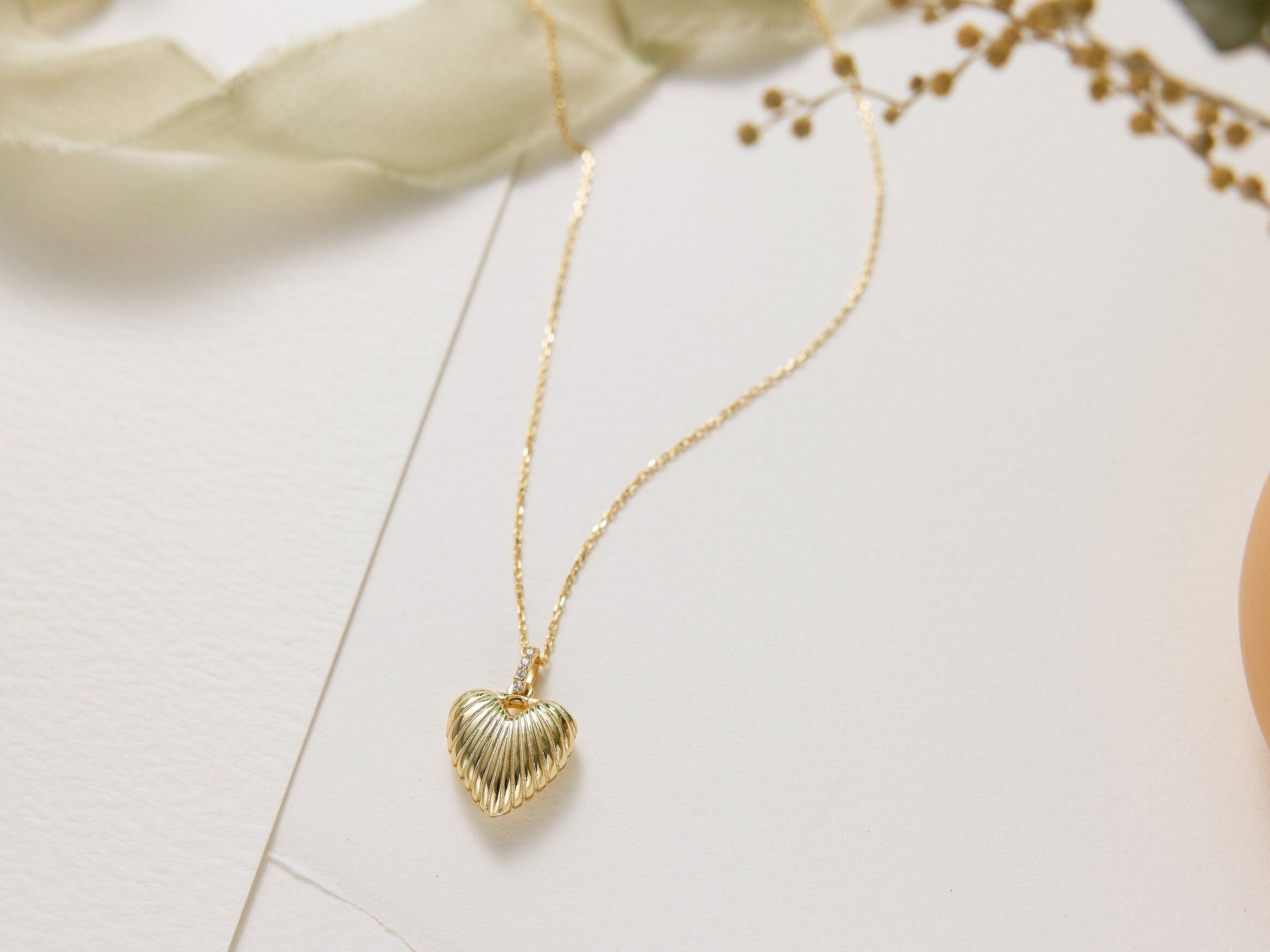 Gold heart-shaped necklace on a light background
