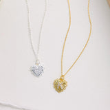 Two necklaces with heart-shaped pendants on a light background