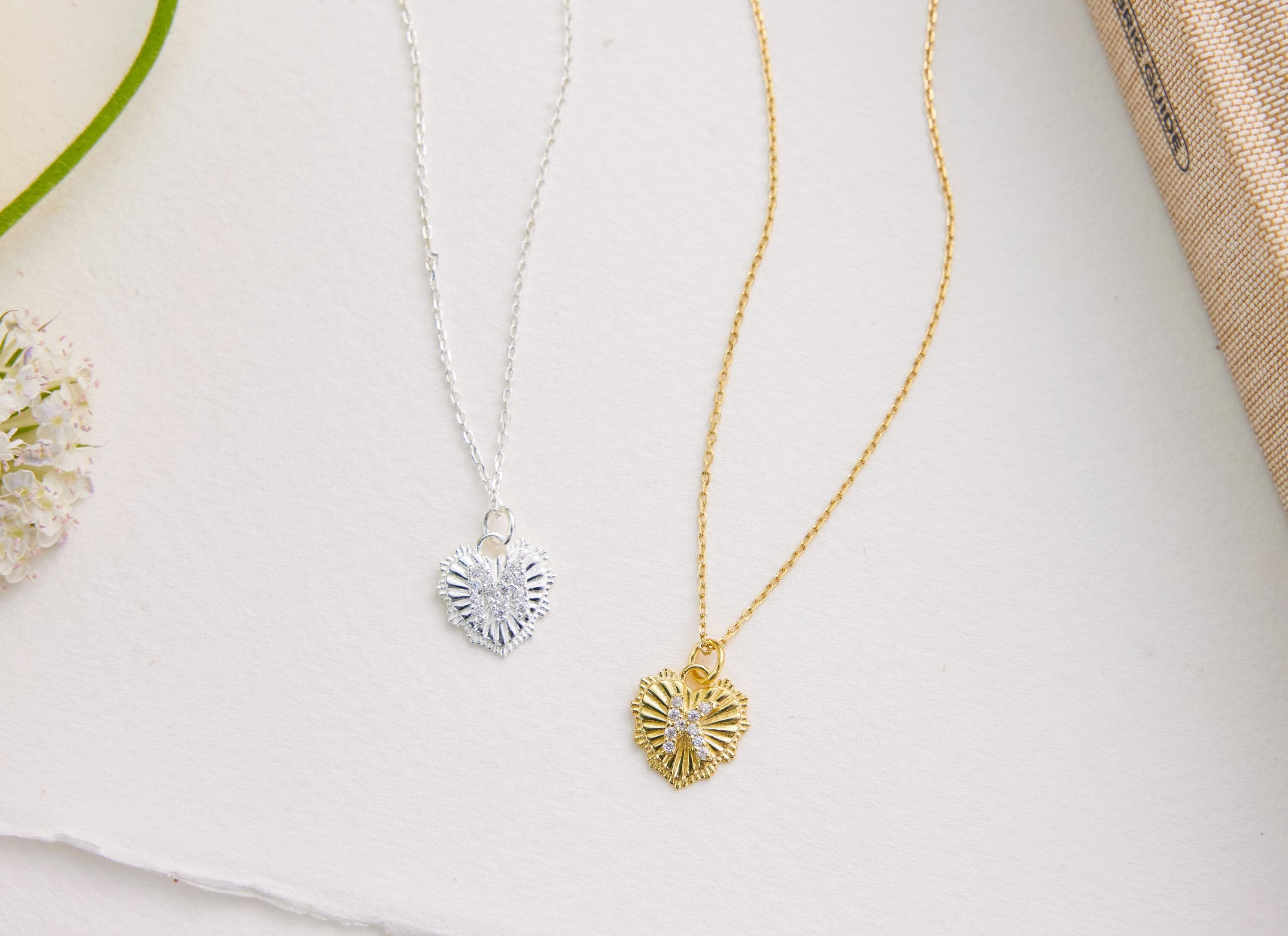 Two necklaces with heart-shaped pendants on a light background