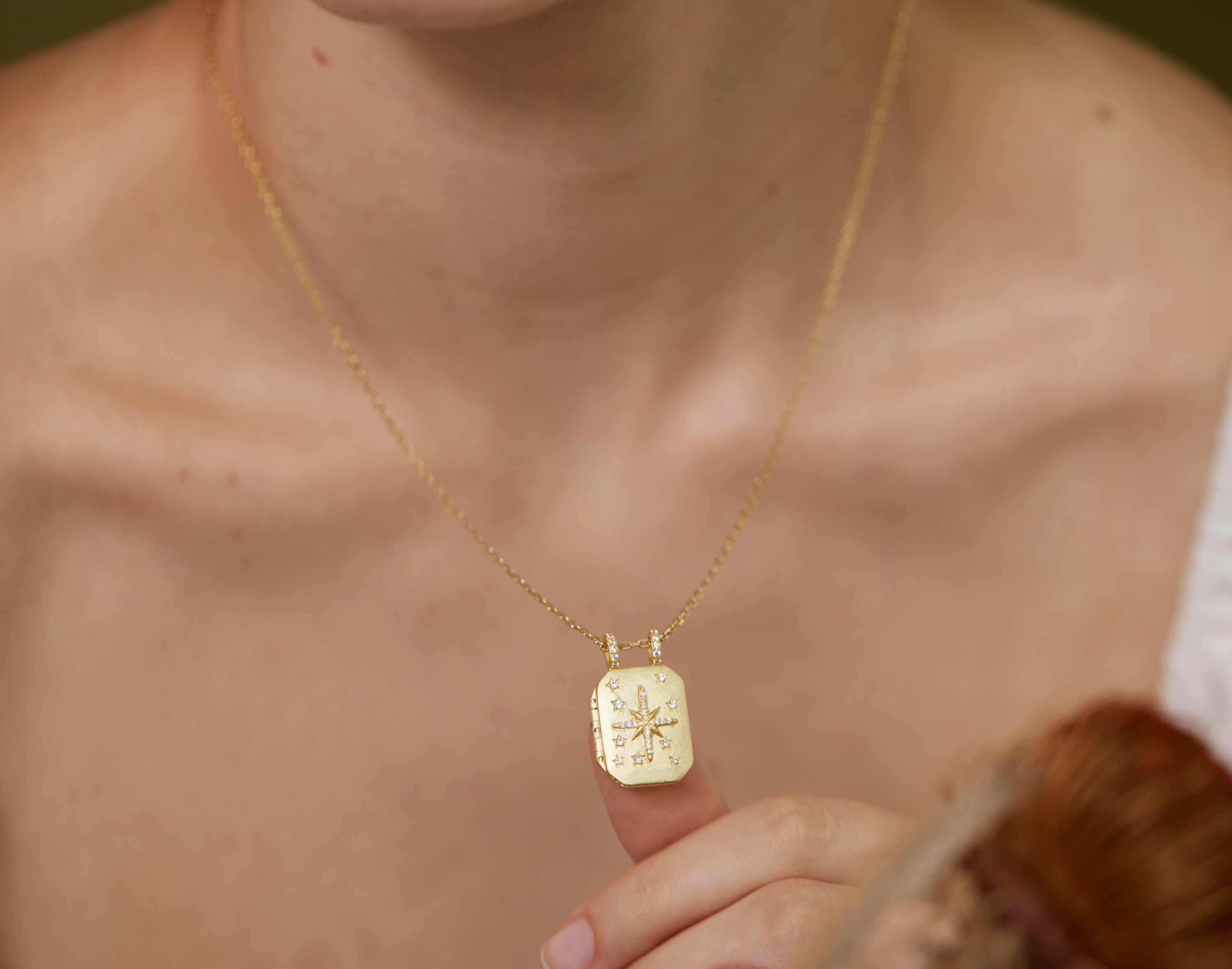 A close-up of a person's neck and chest area wearing a gold necklace with a pendant.