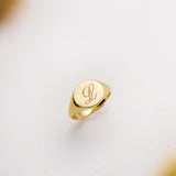 Gold ring with a monogram on a light background