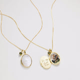 Two gold necklaces with pendants on a light gray background
