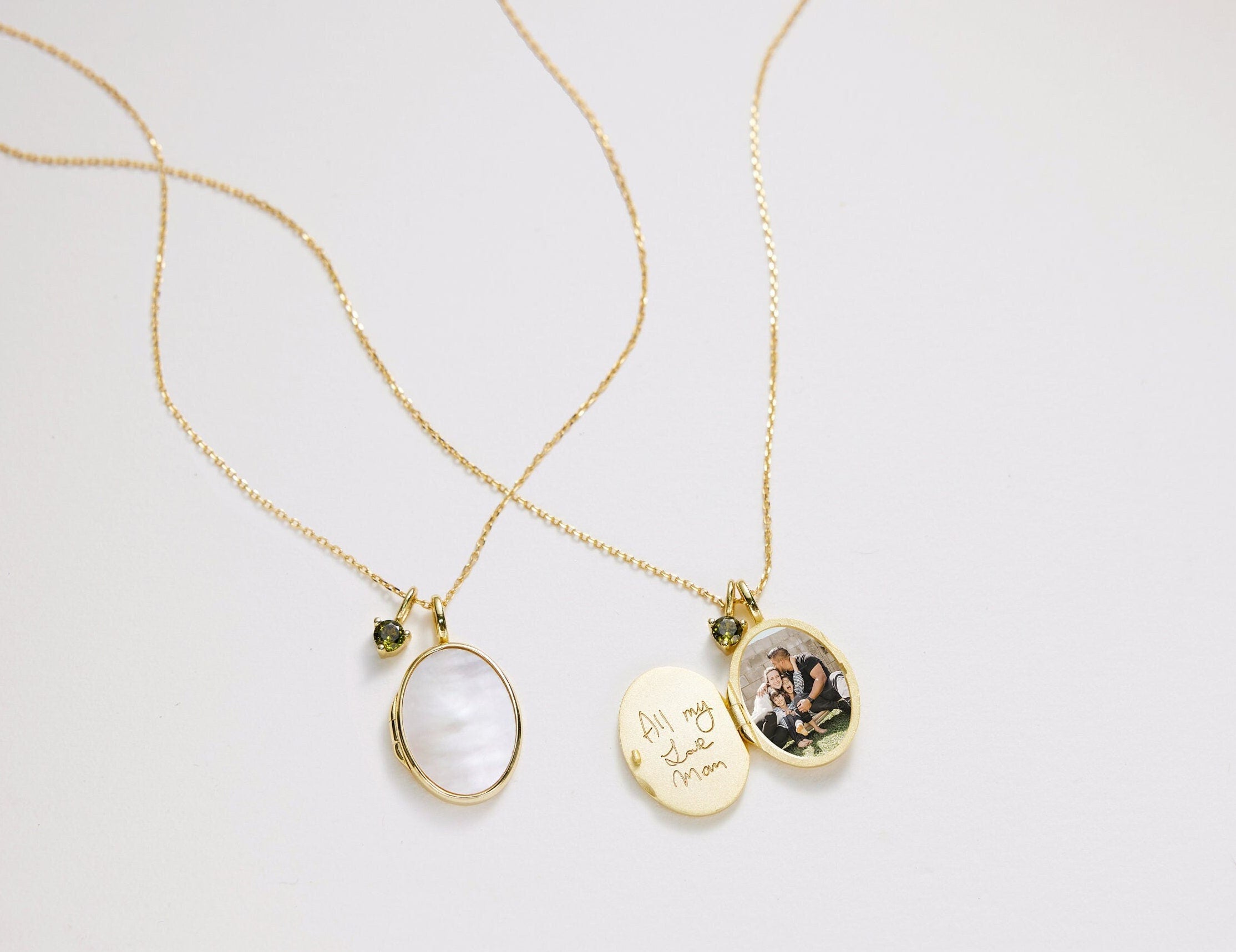 Two gold necklaces with pendants on a light gray background