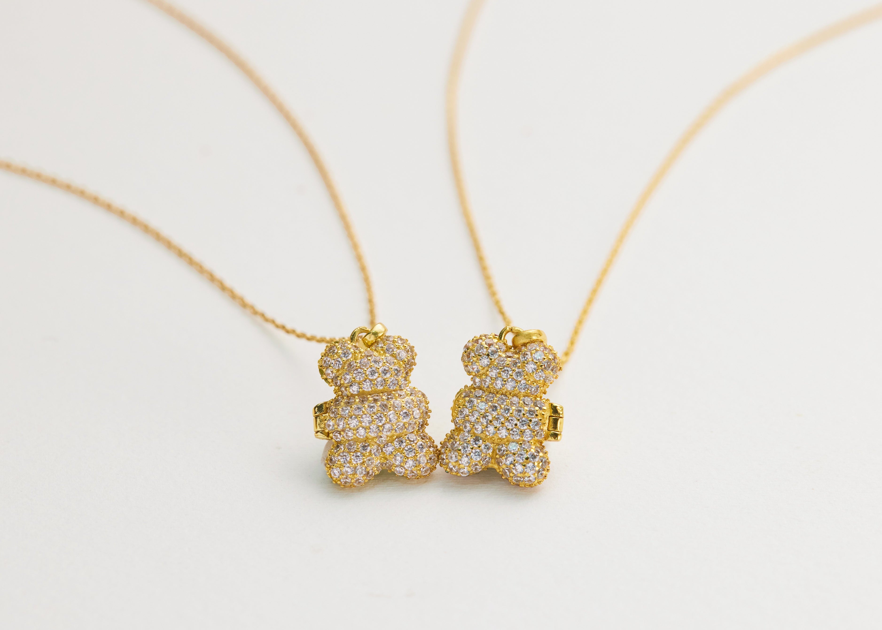 Gold teddy bear necklaces on a white background