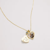 Gold necklace with heart-shaped pendants on a light gray background