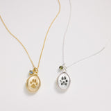 Two necklaces with paw print pendants on a light gray background