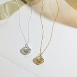 Two necklaces with shell pendants on a light background