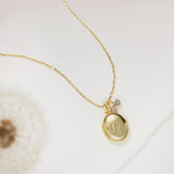 Gold necklace with a pendant on a light background