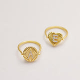 Two gold rings with personalized initial designs on them.