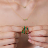 Person holding a green beaded ring with a blurred background