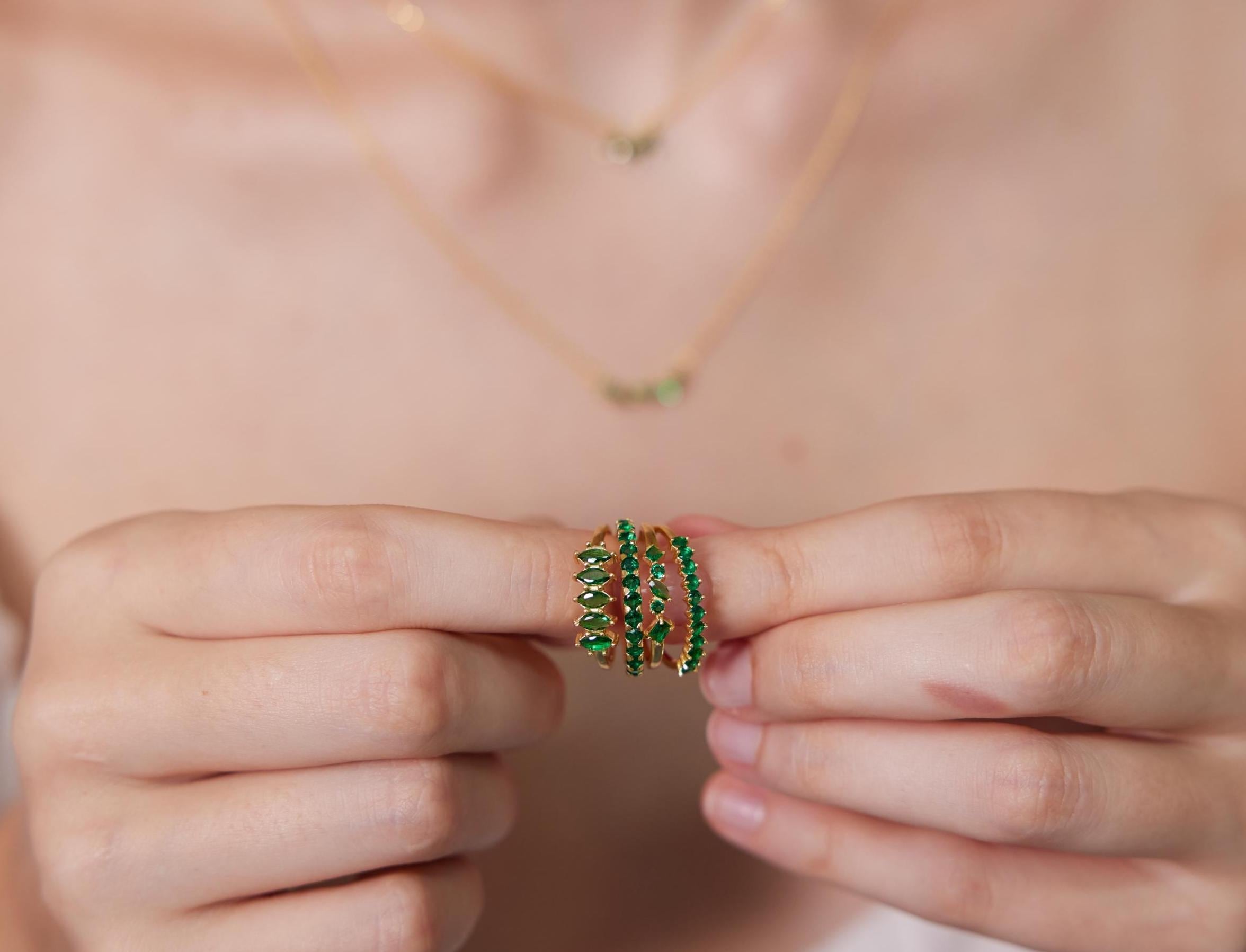 Person holding a green beaded ring with a blurred background