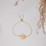 Gold bracelet with a circular design on a light background