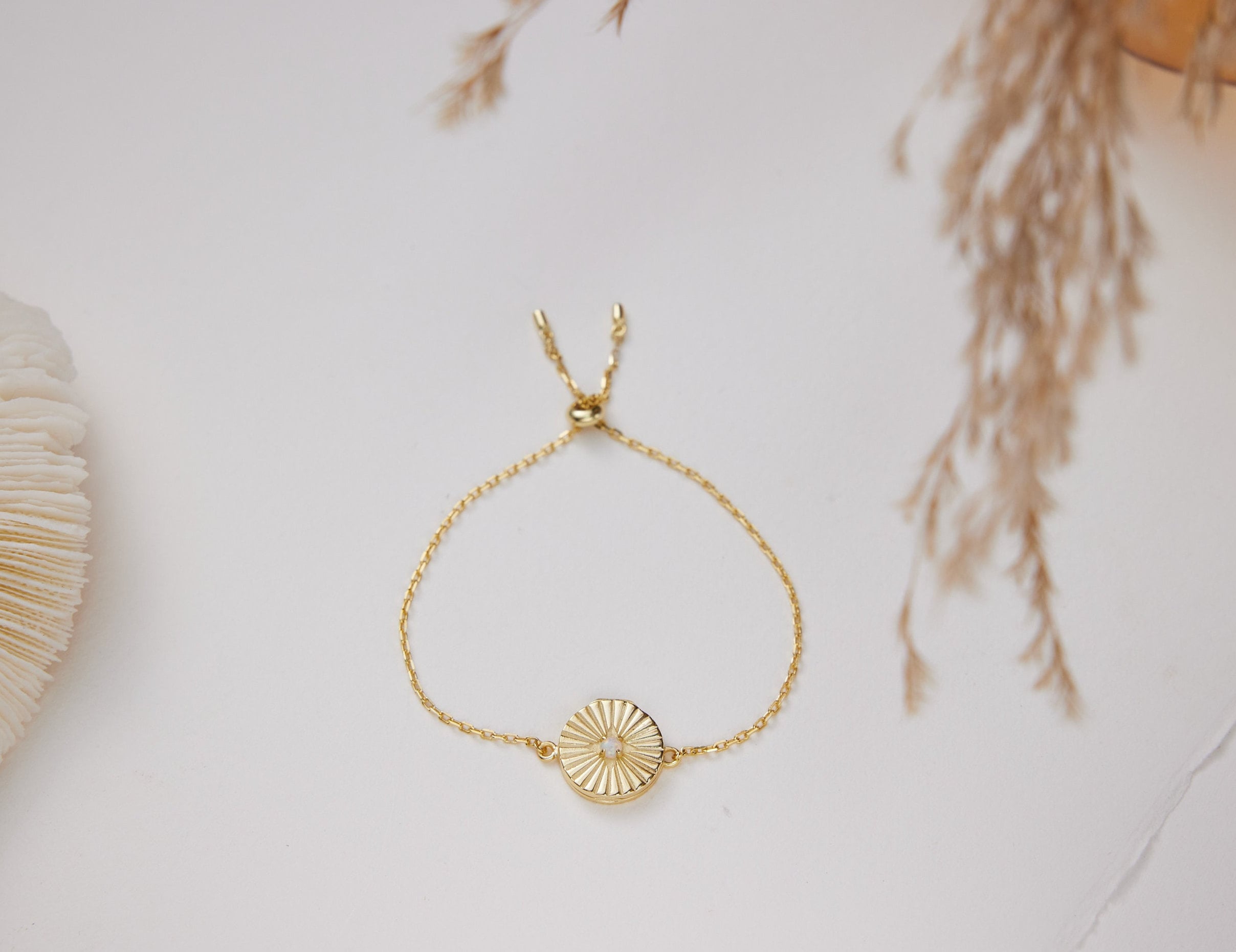 Gold bracelet with a circular design on a light background