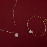 Gold necklace and bracelet with heart-shaped pendants on a red background