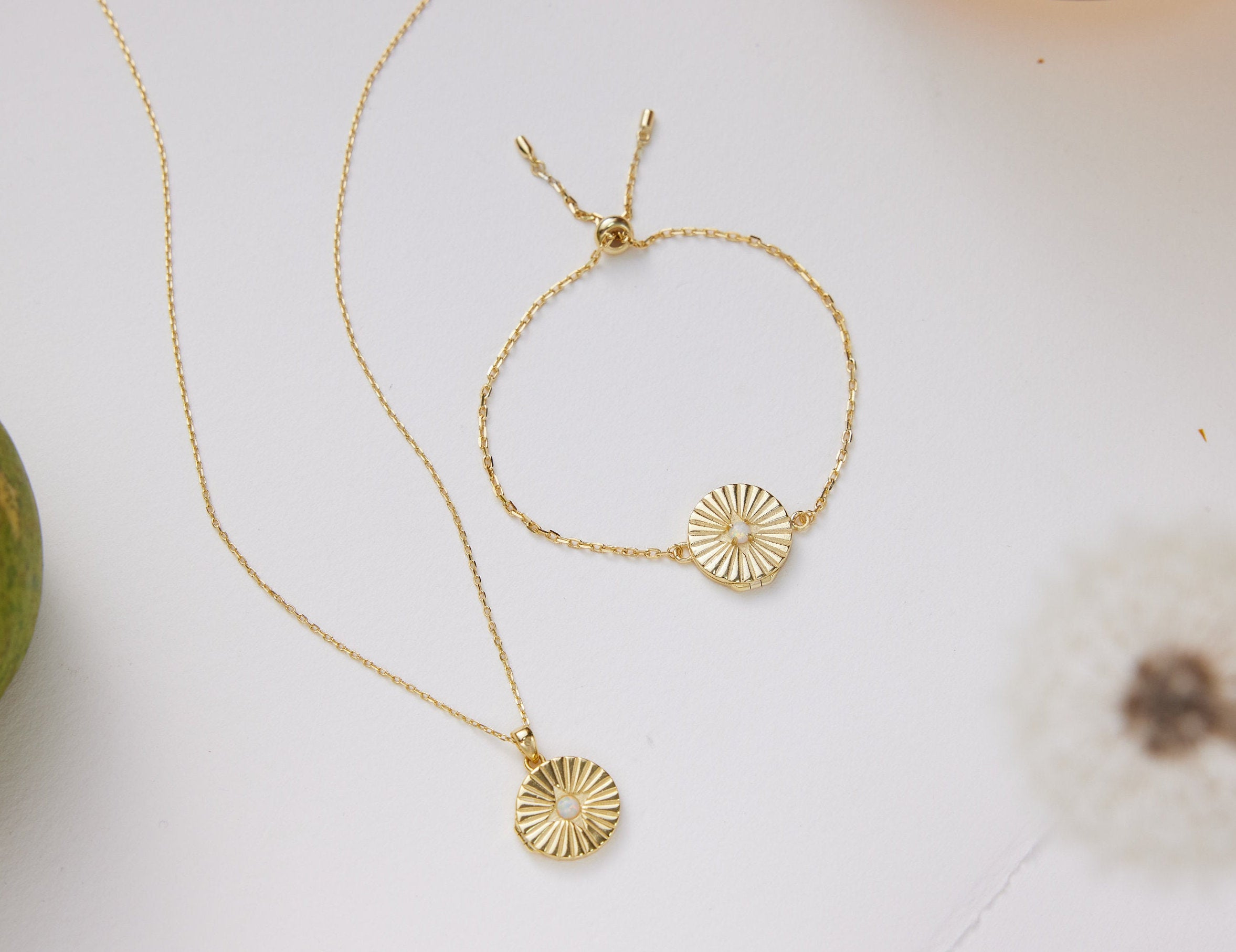 Gold necklace and bracelet set on a white surface