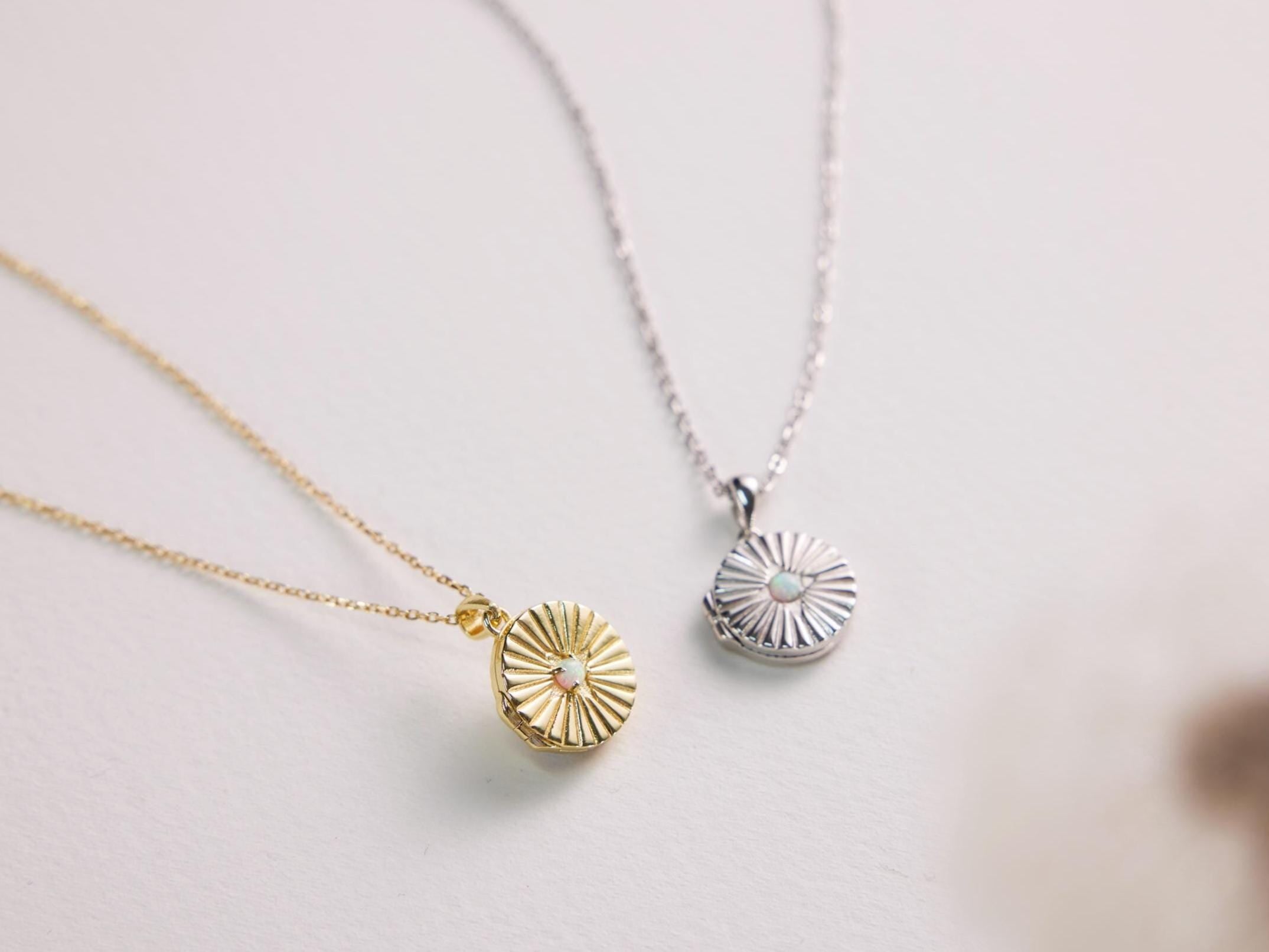 Two necklaces with circular pendants on a light background